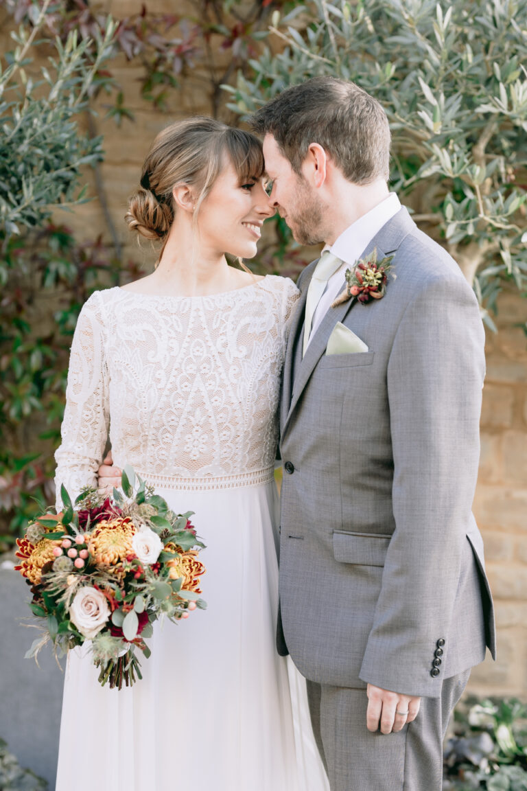 Bride & Groom share a moment under the wooden arbour.