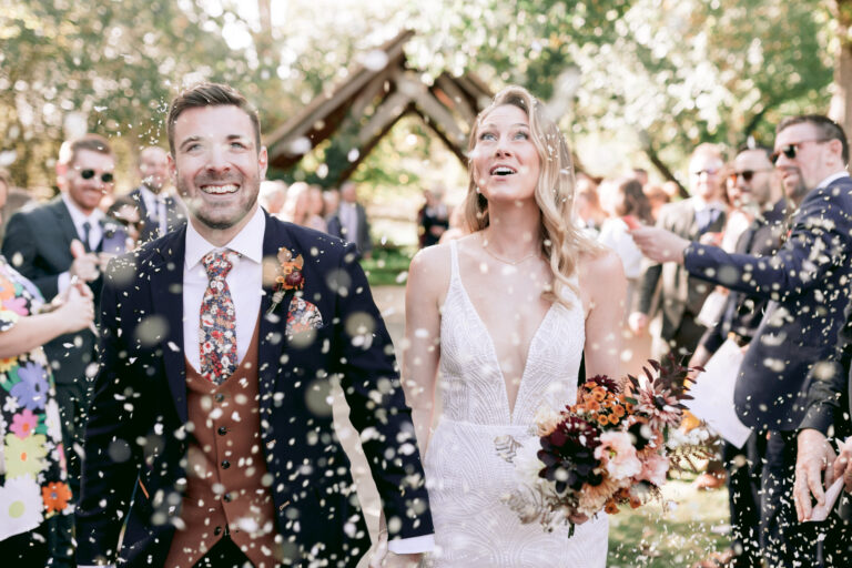 Beautiful couple enjoying their confetti toss at their autumnal wedding at Millbridge Court in Surrey