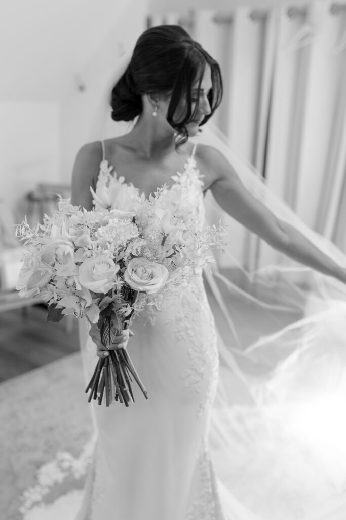 Black and White image of Bride showing off her veil in the bridal loft at Millbridge Court, Surrey.