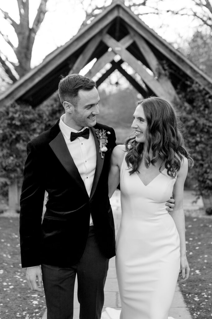 Black and white snap of a couple enjoying a moment in the arbour garden at their black tie wedding in Surrey