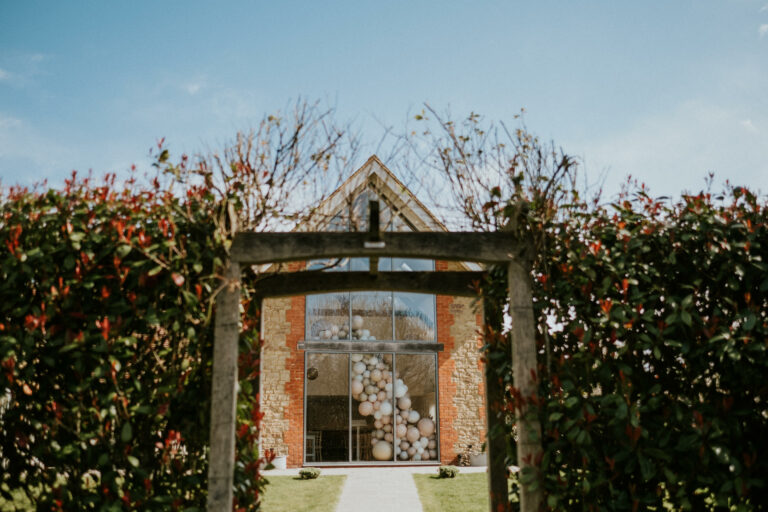 Lauren + Craig looking back from the arbour to the ceremony hall at Millbridge Court